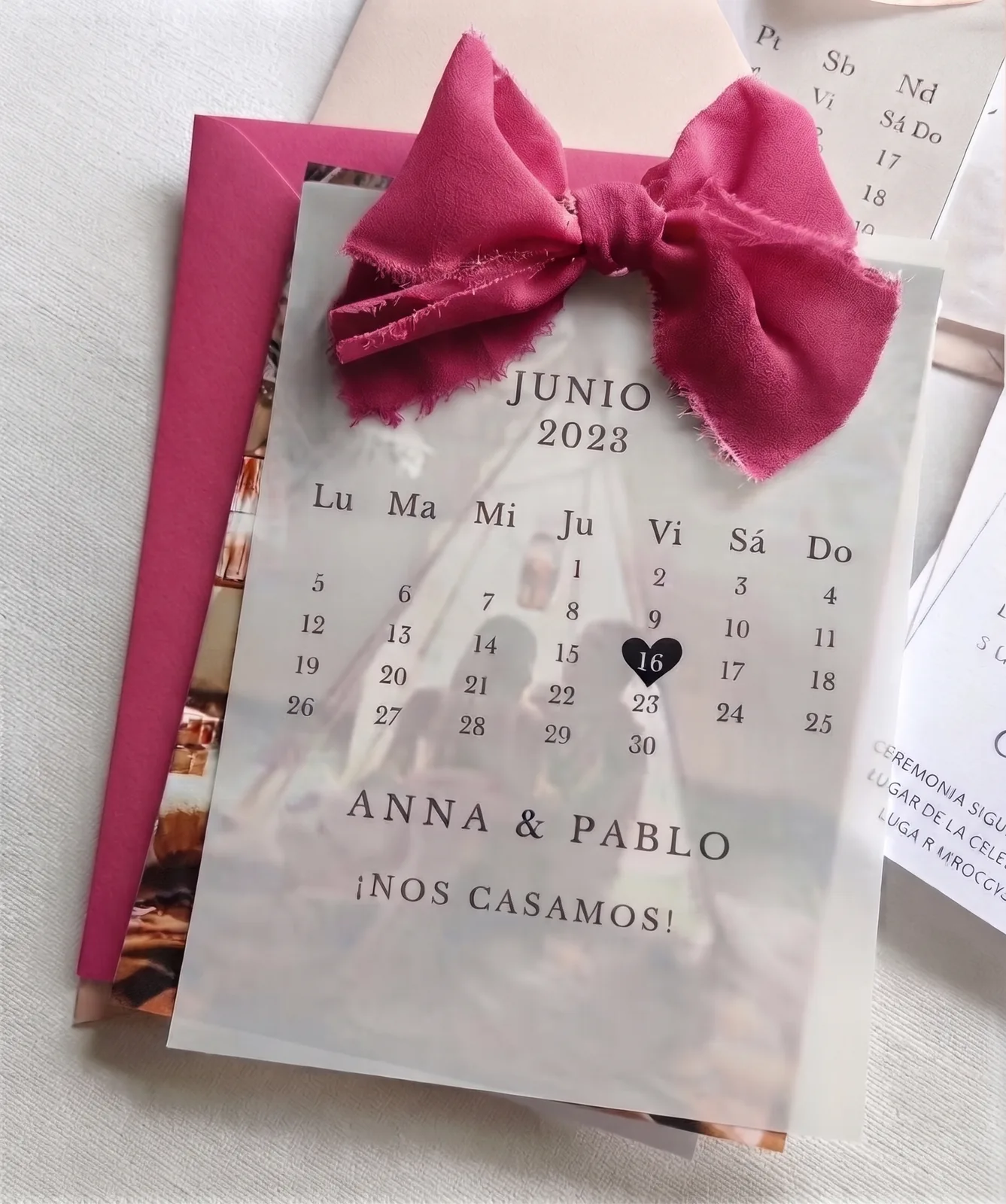 Invitación calendario con papel vegetal, lazo de seda y sobre fucsia