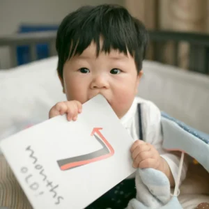 Bebé con una tarjeta de meses (foto de ejemplo)